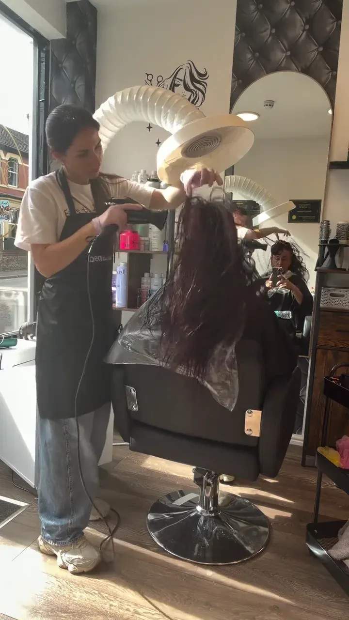 Viktoriia blow-drying a client’s hair in the salon